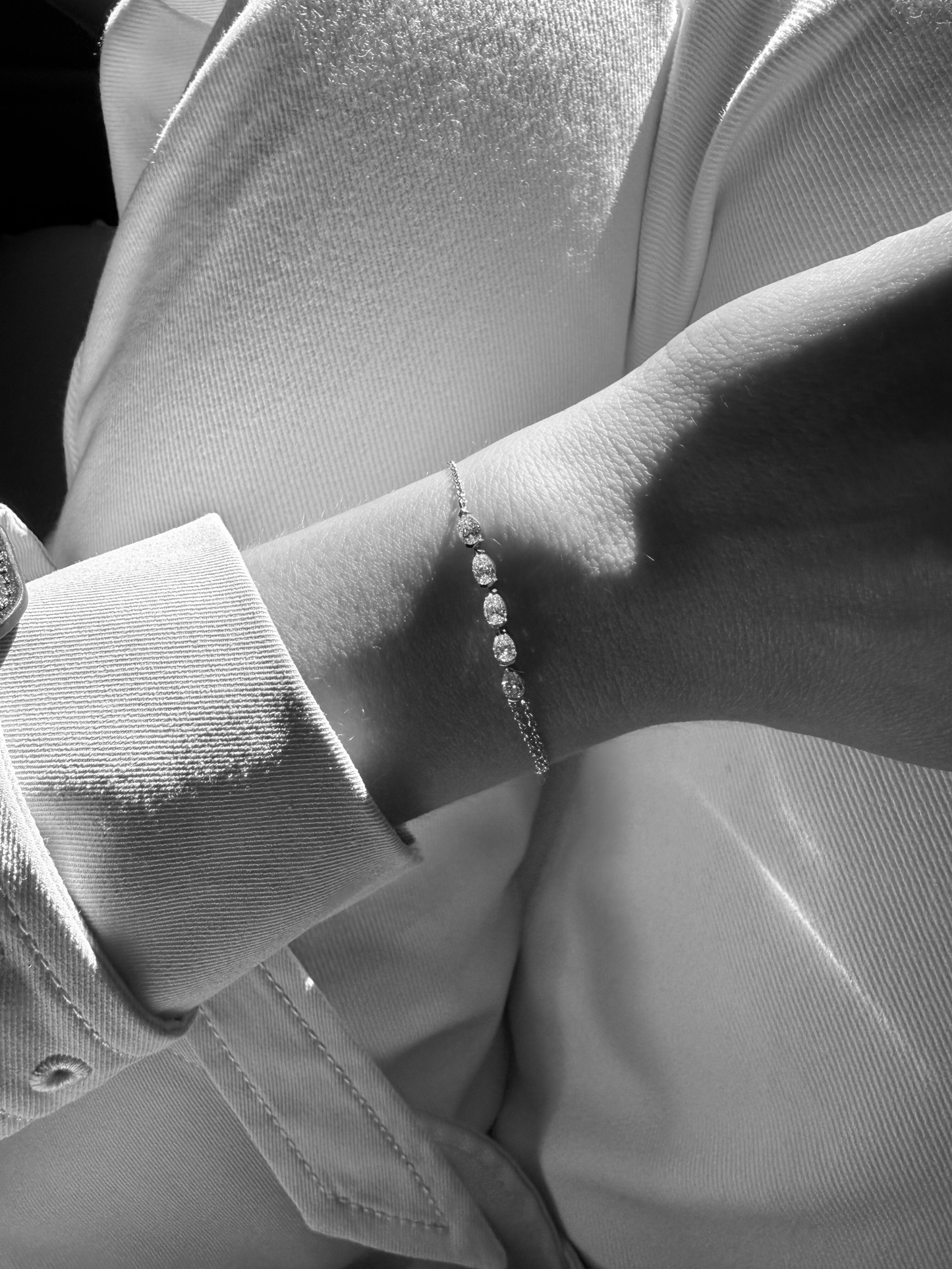 Close-up of five east-west pear diamonds on the GIA white gold bracelet, available with natural diamonds on request