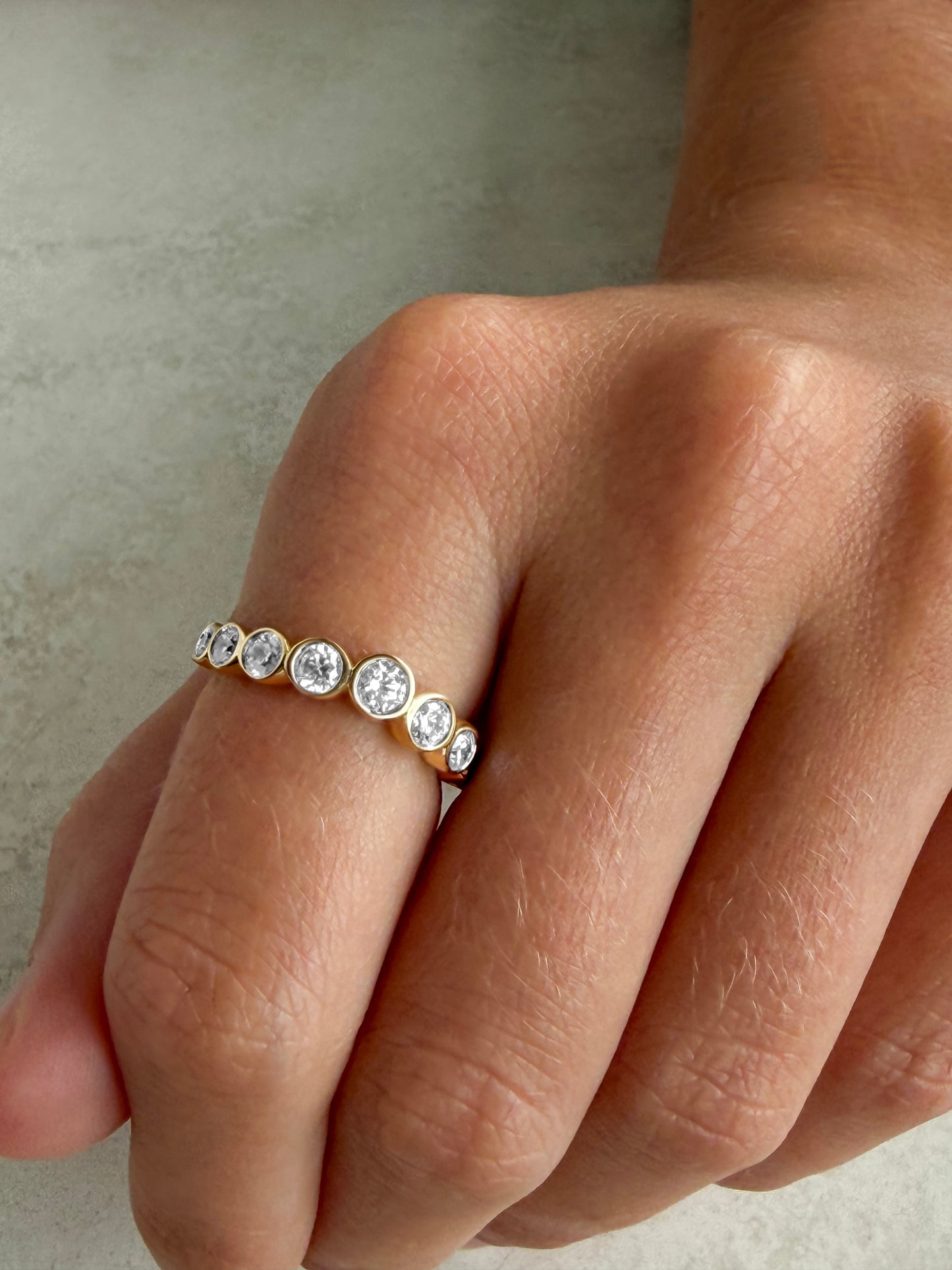 AVA round diamond eternity band worn on hand as a curved wedding band in solid yellow gold, made in Australia by DÉSIR