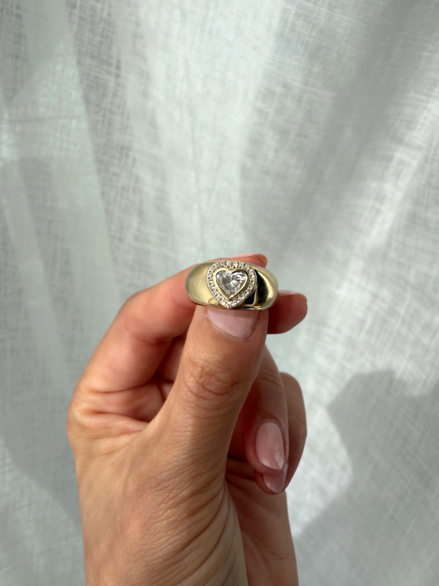 Side view of the DINA signet ring showing a heart-cut lab-grown diamond framed by a pavé halo on a domed gold band