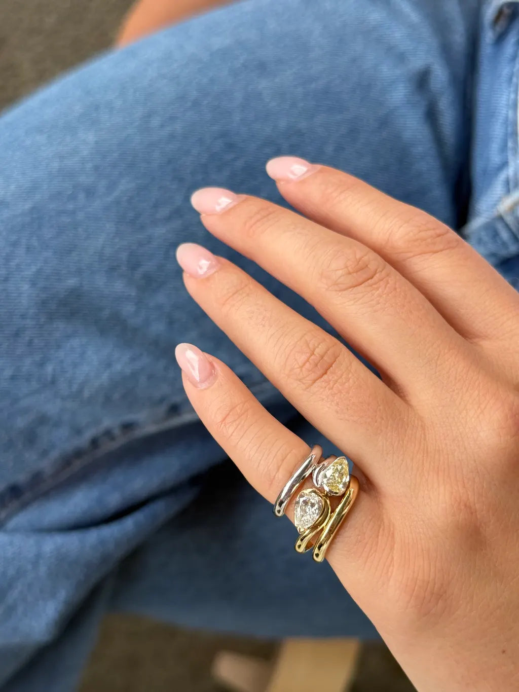 Side view of the GLO pinky ring showing a pear-cut white lab-grown diamond set east-west in a half-bezel scooped band