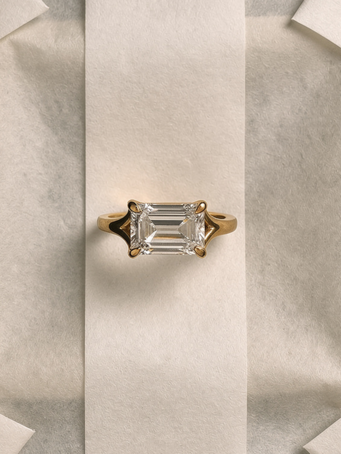 VESPA east-west emerald-cut engagement ring worn on hand in solid yellow gold, a custom piece available with natural diamonds by DÉSIR