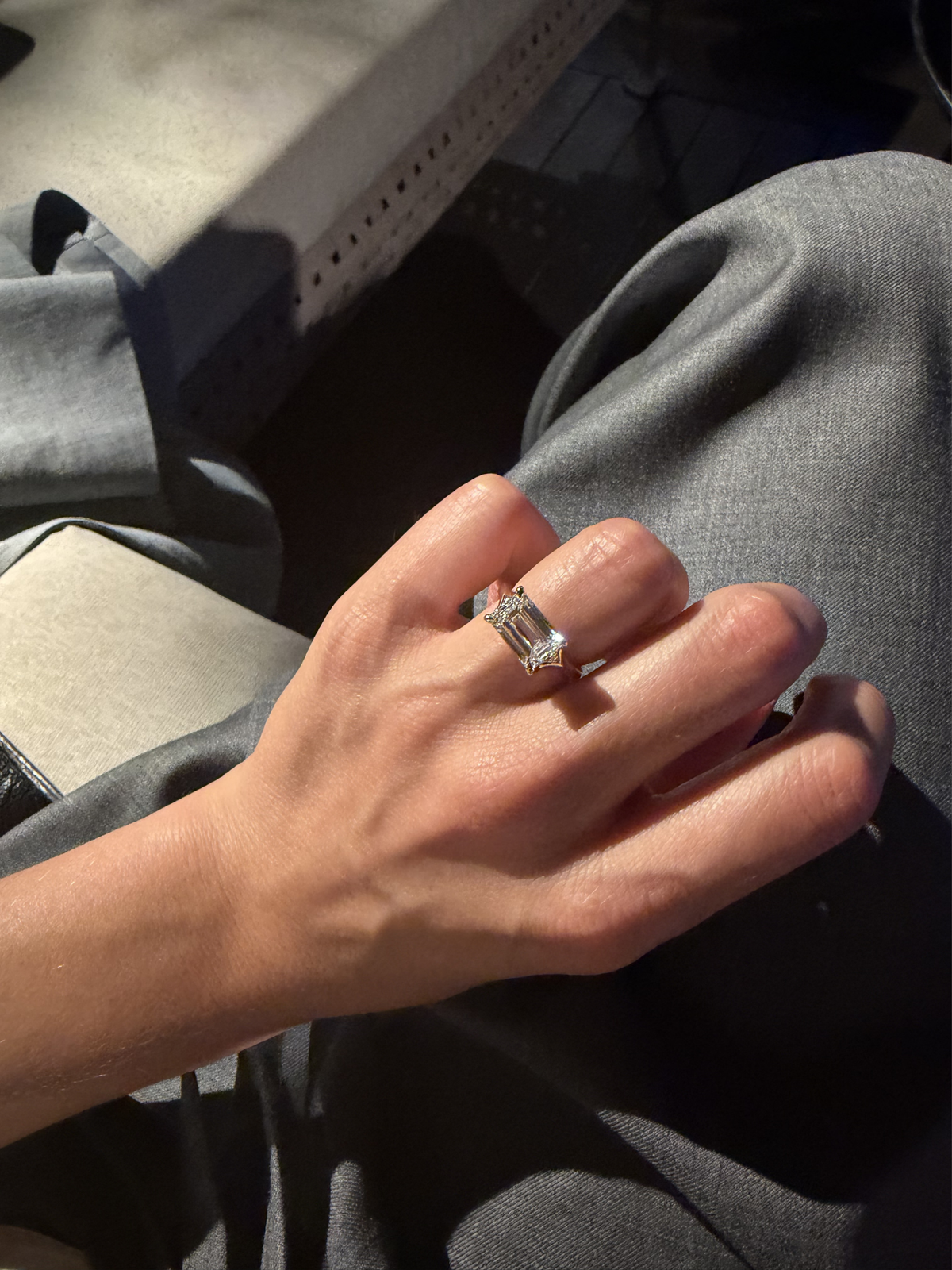 Side view of the VESPA ring, a 3.5-carat emerald-cut diamond raised in an elevated four-prong setting on a split-shank band in 18ct yellow gold