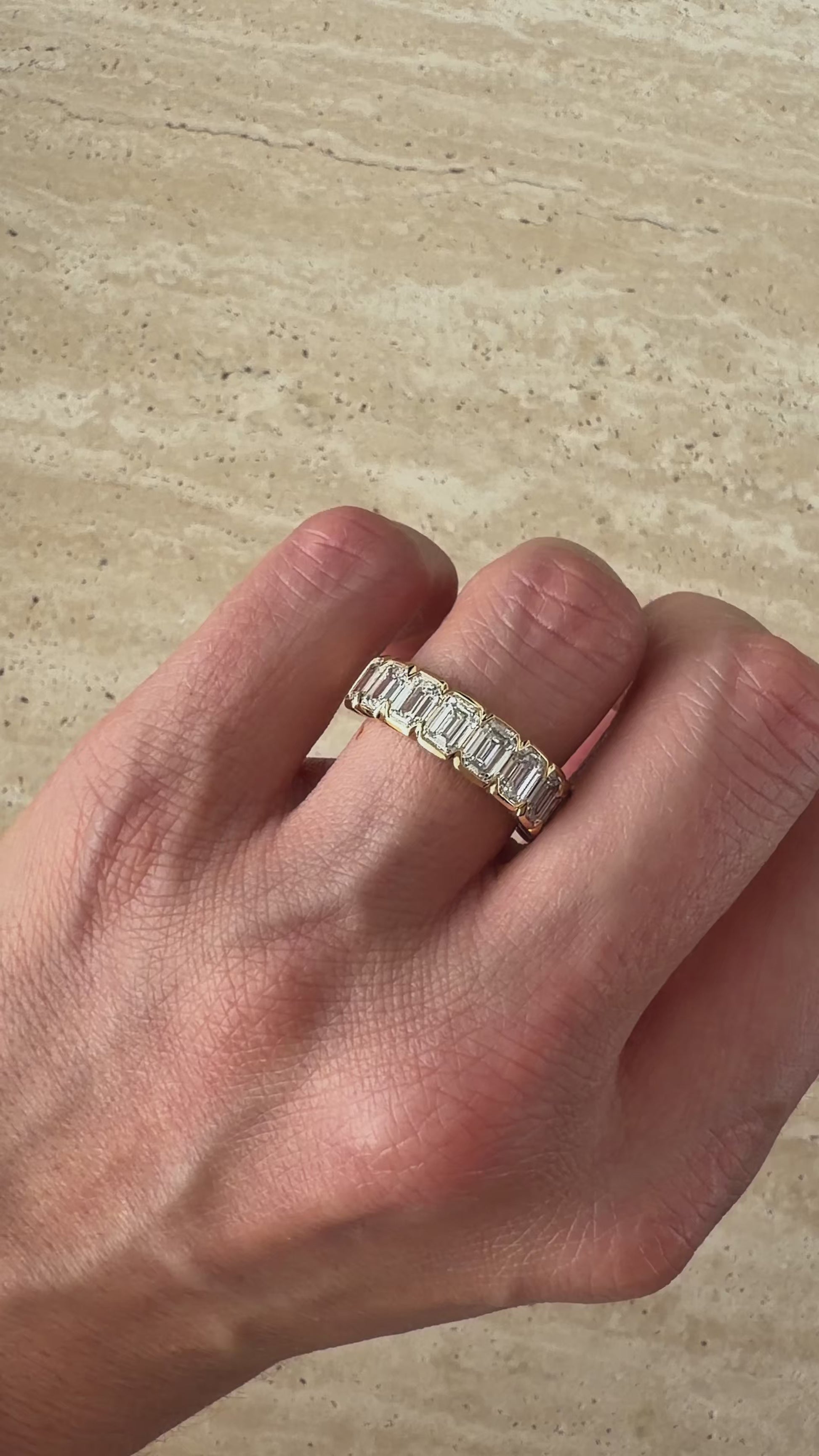 Side view of the ZARA eternity ring showing nine emerald-cut diamonds across a band of solid 18ct yellow gold